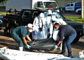 Officials of the Police Board of Investigations (DPI) help employees of the Forensic Medicine Board pick up a black plastic bag containing a corpse in a street in Tegucigalpa on August 19, 2020. - Corpses appeared again in the streets in an upturn of violence in northern Central America, after a truce in the beginning of the new coronavirus pandemic, when social isolation measures were taken to prevent contagions. (Photo by ORLANDO SIERRA / AFP)