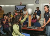 En una clase de Física, una alumna toca una esfera eléctrica. Los grupos de trabajo deben estimar el voltaje que recibió y explicarlo. Al fondo, el profesor Florencio Pinela.