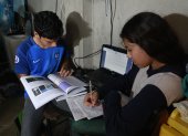 En una vivienda de la cooperativa Sergio Toral, dos hermanos comparten una computadora para recibir las clases no presenciales del sistema educativo público.