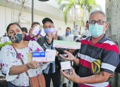 Reclamo. Un grupo de pacientes del IESS muestran las cajas vacías de las medicinas que no reciben.