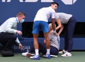 Novak Djokovic intenta socorrer a la mujer luego del pelotazo.