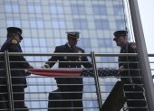 Bomberos se preparan para izar la bandera estadounidense en la conmemoración del año pasado.