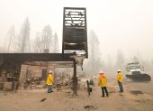 Shaver Lake. Bomberos recorren el lugar donde hasta inicios de semana estaba una tienda. Solo queda el letrero en pie, tras el paso del incendio.