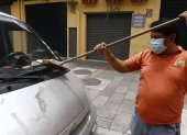 Un ciudadano de Guayaquil retira las cenizas del volcán en un barrio de Guayaquil.