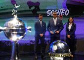 El director de competiciones de Clubes Conmebol, Frederico Nantes (c), posa junto a los trofeos de la Copa Libertadores y Sudamericana.