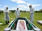 Trabajadores del cementerio Parque de la Paz entierran a un fallecido por covid-19 en el sector de la Aurora.