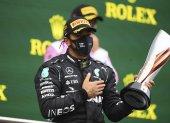 Lewis Hamilton levanta su pulga en señal de victoria tras ganar el campeonato de la Fórmula Uno.