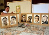 Juan Pablo Zambrano junto a algunos de los retratos que ha plasmado en la pandemia.