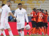 Dentinho de Shakhtar celebra el gol con sus compañeros mientras los jugadores del Real Madrid se lamentan.