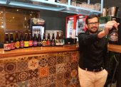 Juan Zurita, sostiene la cerveza de su marca Beerman y exhibe otras artesanales de otras marcas.