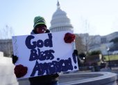 Dios bendiga a América entre los carteles que se puedan leer fuera del Capitolio.