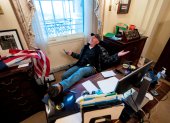 Un seguidor de Donald Trump, identificado como Richard Barnett, se sienta en el escritorio de la presidenta de la Cámara Baja, Nancy Pelosi, luego de irrumpir en el Capitolio estadounidense durante protestas el 6 de enero, en Washington