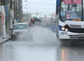 Sur. Dos ciudadanos empapados por el agua que levantó un bus.