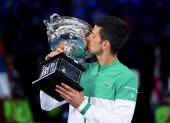 Novak Djokovic besa el trofeo luego de hacer suyo por novena ocasión el Abierto de Australia.