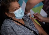 Una enfermera administra una dosis de la vacuna china del laboratorio Sinovac contra la covid-19 a una mujer, hoy en un centro de vacunación en Santiago (Chile).