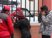 Un bombero habla con una mujer que espera información tras el accidente en el que murieron varios estudiantes hoy, en El Alto (Bolivia).