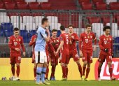 Los jugadores del Bayern Múnich celebran ante el lamento de un jugador del Lazio.