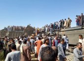Tahta District (Egypt), 26/03/2021.- People stand atop a turned over train carriage as others inspect the scene of a train crash in Sohag province, Egypt, 26 March 2021. At least 32 people were killed and some 66 injured as two passenger trains collided in the Tahta district in Sohag governorate, the Health Ministry announced. (Egipto) EFE/EPA/STRINGER At least 32 dead in train collision in Sohag