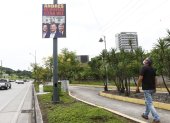 Un ciudadano observa un letrero colgado en la avenida del Bombero, en Guayaquil. Nadie se atribuye su autoría.