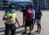 Un agente de Policía dispersa a turistas en la playa de Salinas.