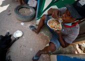 Henrique Silva, de 22 años, almuerza tras recibir una donación de comida en la calle da Paz, el 2 de abril de 2021 en la favela de Paraisópolis, en Sao Paulo (Brasil).
