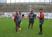 Athy Lozano (i), Jonathan Capuz y Bryan Caisabanda (d), jugadores indígenas de Mushuc Runa, mientras conversan con Geovanny Cumbicus, entrenador de Ponchito.
