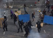Manifestantes se enfrentan con miembros del Escuadrón Móvil Antidisturbios (ESMAD) durante las protestas hoy en Cali (Colombia).