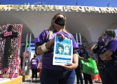 Perla Reyes, madre de Jocelyn Calderón Reyes, muestra hoy un cartel con una imagen de su hija, durante una protesta para exigir el esclarecimiento del caso tras 9 años de su desaparición en Ciudad Juárez.