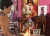 Nube Dolores mantiene todo el día una vela encendida por su hija Johanna Tapia. Su foto está en medio de varias imágenes de santos.