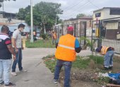 Moradores y policías limpian las aceras de un parque en el Guasmo sur de Guayaquil.