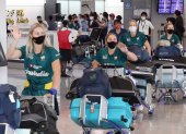 Las seleccionadas del equipo australiano de sóftbol arribando al aeropuerto tokiota de Narita.