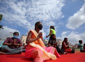 Niños con discapacidades visuales y entusiastas del yoga que usan mascarillas practican la meditación en el Día Internacional del Yoga en Bangalore, India.