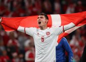 Andres Christensen muestra una bandera danesa luego de la victoria frente a Rusia.