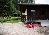 Un coche aparece semienterrado por las inundaciones en Schoenau am Koenigssee, Alemania.