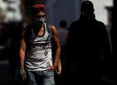 En la imagen, un hombre con mascarilla camina por una calle de Quito (Ecuador).