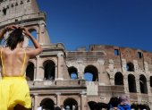 Una turista con ropa ligera visita el Coliseo Romano.