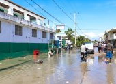 Grupos de personas transitan por una calle inundada tras un seísmo de 7,2 grados hoy, en Los Cayos (Haití).