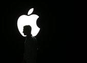 La silueta de un hombre se ve frente al logo de Apple, en una fotografía de archivo.