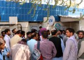 Afganos aguardan afuera de un banco cerrado en Kabul, Afganistán, para intentar retirar dinero.