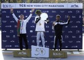 El ganador del maratón de Nueva York, el keniano Albert Korir (c), el subcampeón, Mohamed El Aaraby (i), y el tercer lugar, Eyob Faniel, festejan durante la premiación de la carrera.