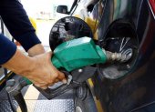 PISTOLA DE DISPENSADOR DE COMBUSTIBLE MIENTRAS LLENA EL TANQUE DE GASOLINA DE UN AUTO |