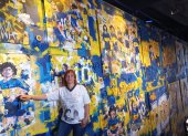 Mariana Vega, integrante de la Iglesia Maradoniana, junto a un mural del astro que pintó Boca Juniors.