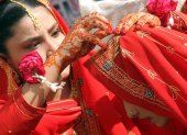 Dos novias se ayudan a colocar el pañuelo durante su ceremonia matrimonial múltiple en Karachi (Pakistán) en una imagen de archivo. EFE/Rehan