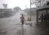 ARCHIVO - Un migrante lleva bajo intensa lluvia un bidón de agua potable a un depósito que sirve de refugio para migrantes en el Tapón del Darién. Foto: Mauricio Valenzuela/dpa ag-periodistas