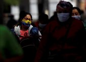 Referencial. Personas con mascarilla caminan por una calle en la ciudad de Quito.