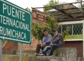 Dos conductores ecuatorianos esperan en el paso de Rumichaca a la devolución de su camión desde Colombia por un conductor de ese país antes de la reapertura de la frontera.