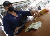 Una foto referencial de como los trabajadores están contando su dinero para ver para qué le alcanza al haber recibido un décimo recortado.