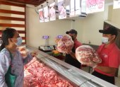 Comercio. Una cliente selecciona una pierna de cerdo en uno de los locales de Servicárnicos, en la Alborada.