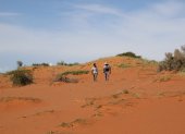 Los científicos Keafon Jumbam (izq.) y Olufemi Olubodun, caminan en la arena roja de la Reserva Natural de Tswalu, en el desierto del Kalahari.