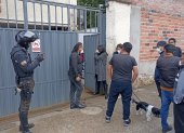 Afectada junto a familiares y curiosos en la puerta de la vivienda donde se robaron el dinero de la caja fuerte.